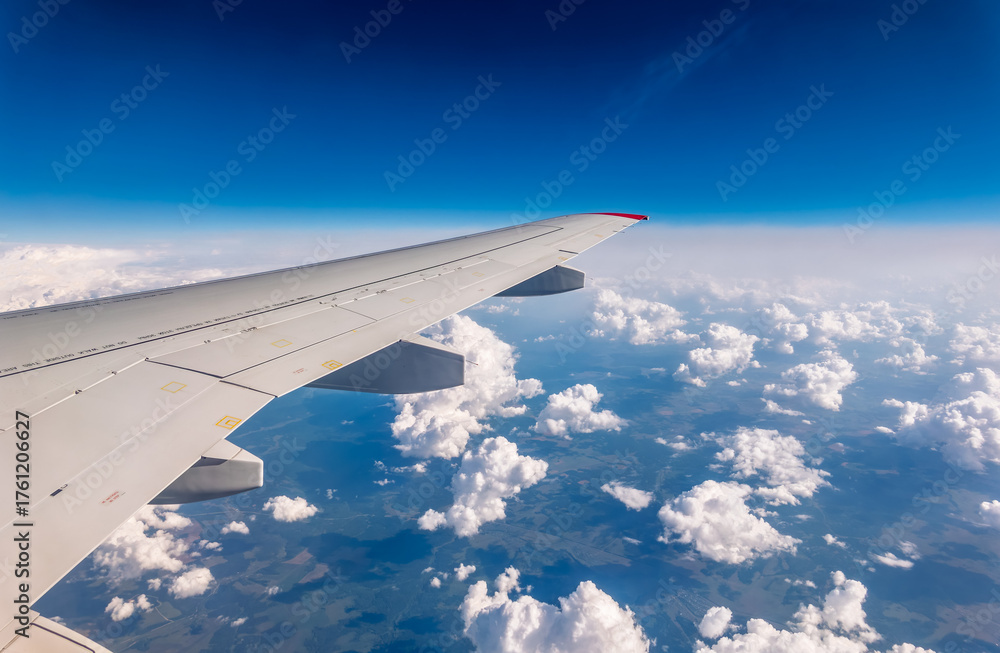 Obraz premium View from the airplane window at a beautiful cloudy sky and the airplane wing