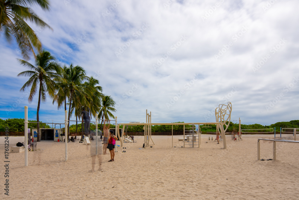 Fototapeta premium Muscle beach Miami. Long exposure of people working out. Blurry people and clouds