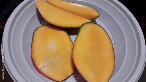 Plate of sliced mango. Mango tropical sweet fruits. Reddish skin Keitt variety mango slices video footage.
