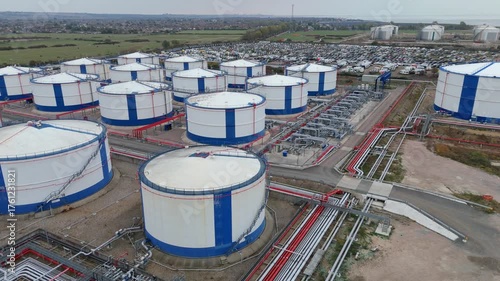 Aerial drone view of Oil and fuel gas terminal storage silos. Industrial petrochemical tankers and pipe work for transportation near Canvey Island on River Thames , United Kingdom  
