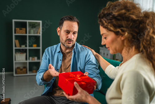 Canvas Print Woman offering reconciliation gift to reluctant man