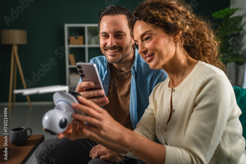 Obraz na plátně Couple setting up smart home security camera using smart phone