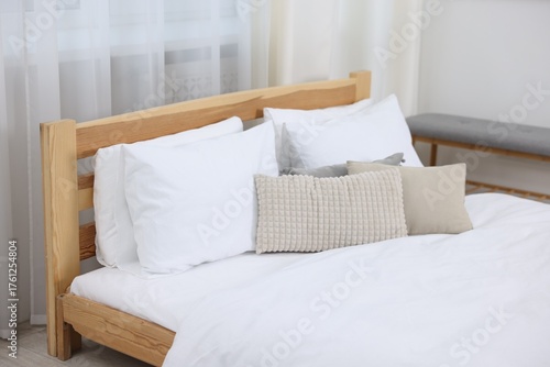 Bed with fresh white linens indoors, closeup