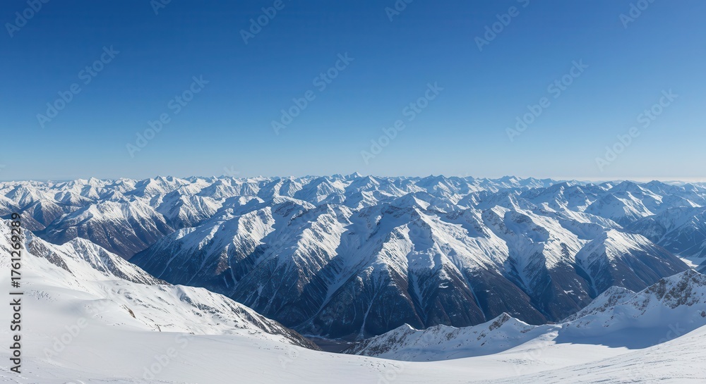 Naklejka premium Vast mountain range covered in snow under a clear blue sky.