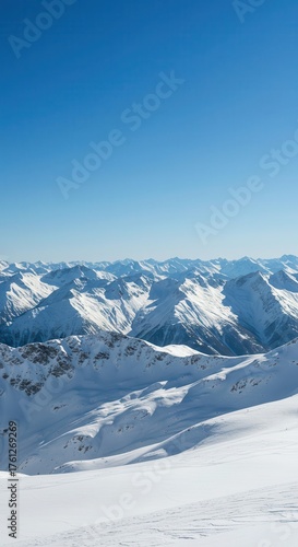 Snow-covered mountain range under a clear blue sky on a sunny day.