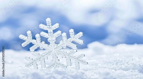 Close-up of a delicate snowflake resting on fresh white snow, set against a soft, icy blue winter background