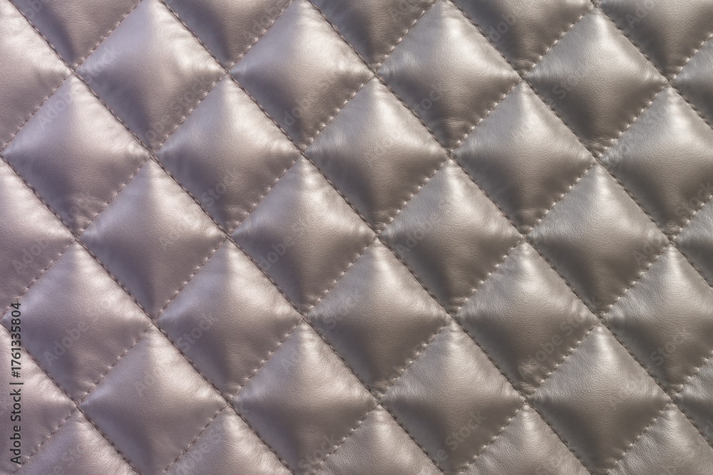 Obraz premium Luxurious quilted satin fabric texture with elegant diamond pattern and soft padded surface