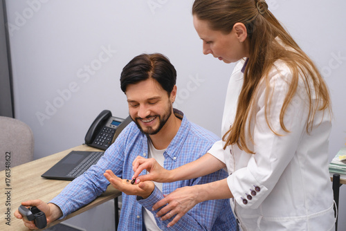 Fototapete Otolaryngologist showing Modern miniature hearing aids for mid aged man at modern medical center