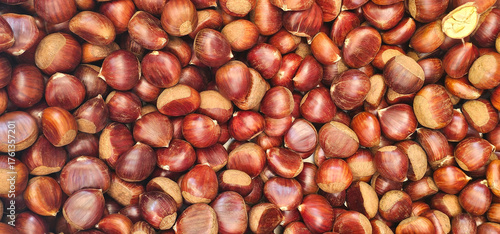 Foto Fresh chestnuts with rich brown shells fill the frame in a colorful display at a local Granada market, ready for roasting or cooking