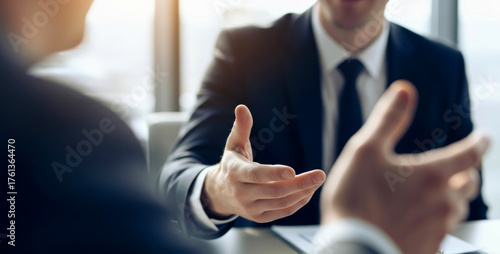 Businessmen in elegant suits gesturing dynamically during a professional indoor meeting or negotiation, capturing teamwork, confidence, and strong communication in a modern corporate space.