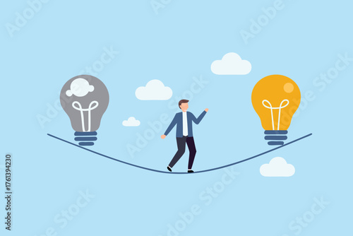 Businessman walking a tightrope between a dark and a bright idea bulb with clouds in the background
