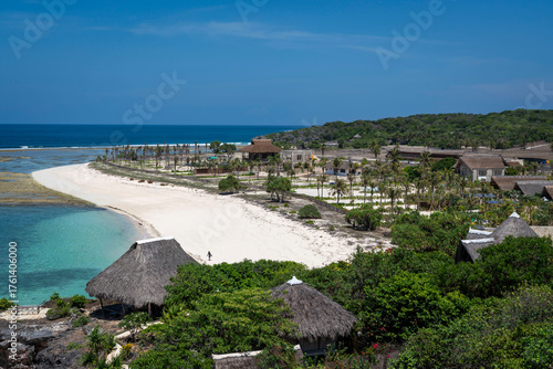 Obraz na plátně Stunning high-angle view of an exclusive tropical resort situated on a crescent-shaped white sand beach