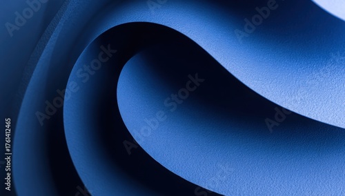 Curved layers of textured blue paper forming a spiral abstract pattern with smooth gradients and dramatic light and shadow play.