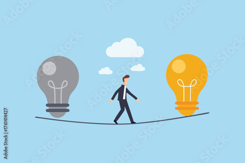 Businessman walking a tightrope between a gray and a glowing yellow light bulb symbolizing ideas