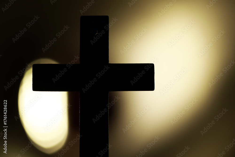 Naklejka premium Silhouette of a Cross Against Dramatic Backlit Glow Capturing Spiritual Serenity