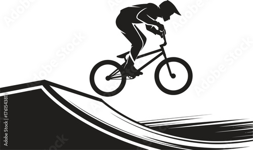 Silhouette of a bmx rider performing a jump on a ramp