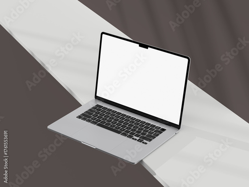 Silver laptop with an empty screen, sitting on a light desk with clean edges.