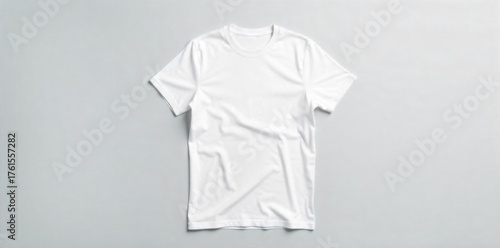 Isolated White T Shirt Blank on Seamless Gray Background with Soft Shadows A studio photograph of a plain, unbranded white t shirt laid flat on a seamless, light gray background. The lighting is soft