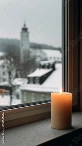 Candle glowing softly near window, snowy landscape visible outside, creating warmth