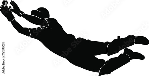 Silhouette of a cricket player diving to catch a ball