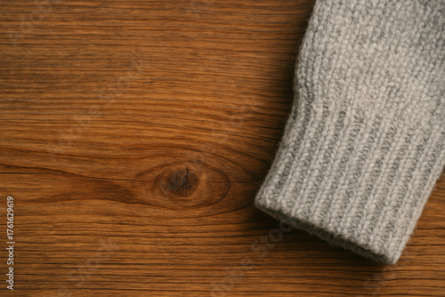 Knit Cuff on Wooden Surface – wide left copy space / 木目とニットの袖口（左余白広め）