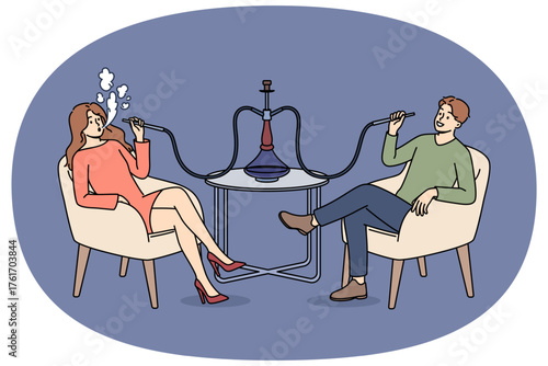Man and woman smoke turkish hookah, sitting at table in bar and enjoying taste of tobacco. Dating of happy couple with hookah, for opportunity to chat and relax in comfortable atmosphere