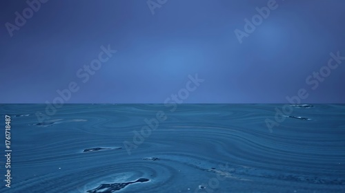 Vast expanse of tranquil blue ocean water with subtle ripples and abstract patterns under a clear sky