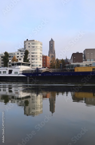 Skyline of Arnhem in the Netherlands. With the Eusebius church and a cargo ship on the river Rhine. Also a beautiful reflection in the water.