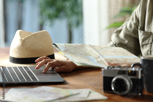 Tourist planning vacation checking maps and laptop