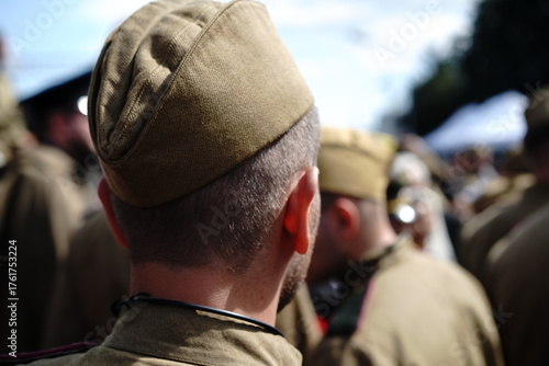 Soldiers gathered in uniform during a historic reenactment event at a military parade in summer