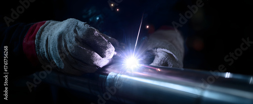 Steel frame welding joint shines like a lightning bolt guarded by trusty protective gloves.