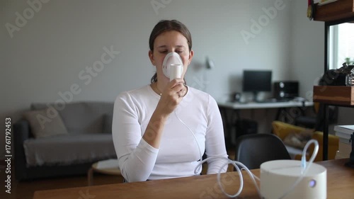 Young woman using a nebulizer at home