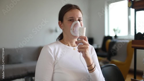 Young woman using inhaler to manage breathing