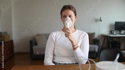 Young woman using a nebulizer mask to manage breathing