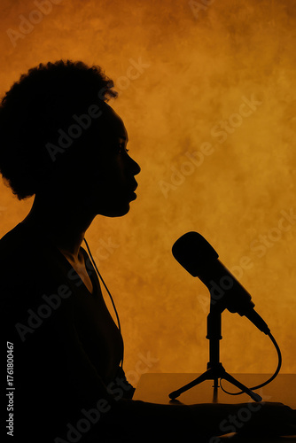 Silhouette of person speaking into microphone against warm orange background representing podcast radio broadcast voice recording and communication art concept