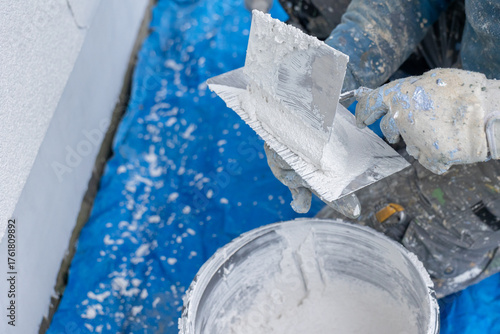 Construction worker plastering wall during house renovation