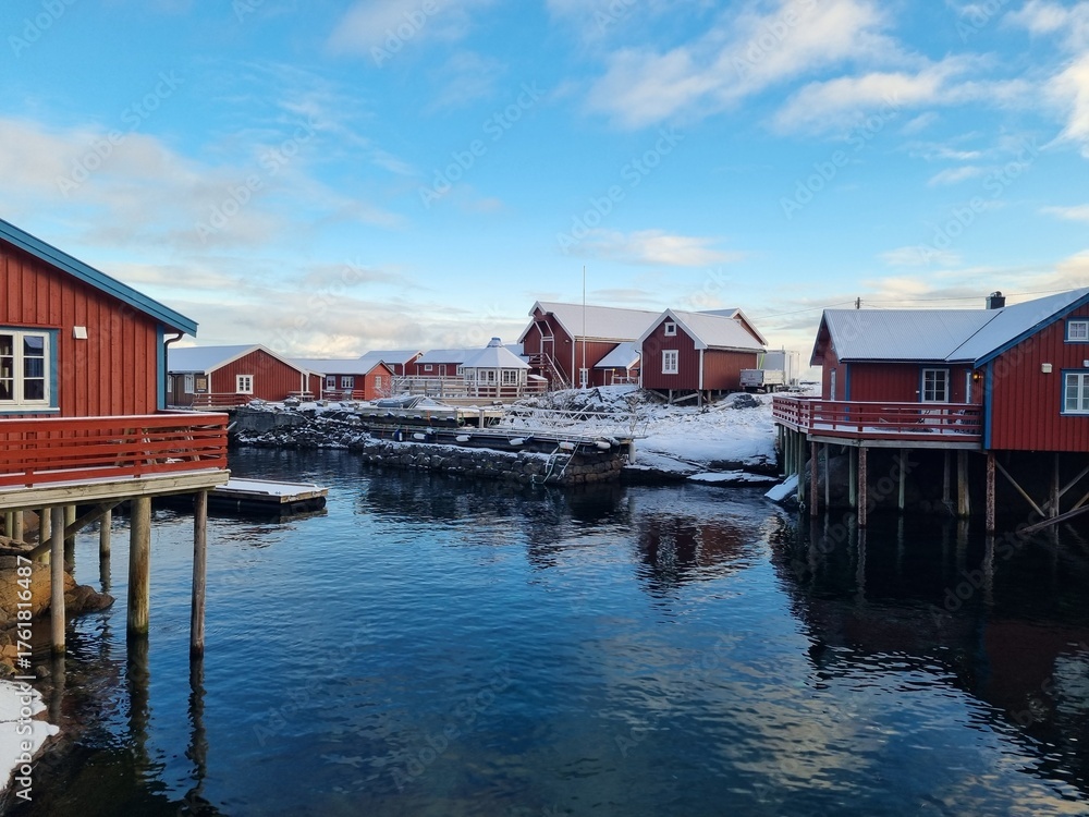 Fototapeta premium Charming winter views of the historic fishing village A (Å) in Lofoten, Norway, featuring colorful wooden buildings, and snowy peaks. 