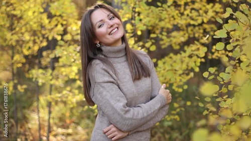 Portrait of a beautiful young woman enjoying autumn against the backdrop of the forest