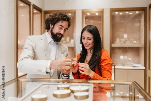 Fotografie Young happy couple standing at a display counter, looking at different luxurious