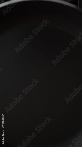 Overhead shot of a stove burner igniting with vibrant red-blue flames. A frying pan is placed on the fire, ready for cooking