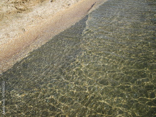Beautiful clear water reflecting sunlight along the peaceful coastal shore