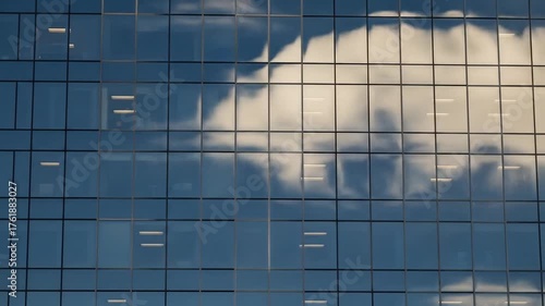 Modern facade reflects the sky dotted by office lights late in the day