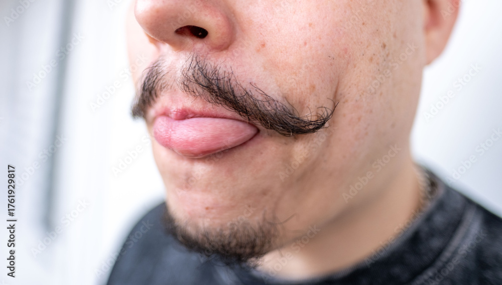 Obraz premium middle-aged man playfully sticking tongue, elegant, well-groomed mustache and serious expression, Authentic male portrait confidence, mature masculinity, self confident, Gentlemanly style male face