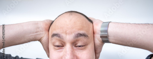Foto Close-up brown-eyed short-haired man holding head in pain, suffering from headac
