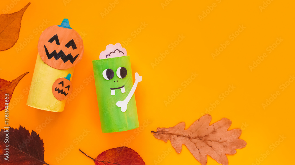 Naklejka premium Halloween monsters from toilet paper roll tube, easy DIY handmade decorations idea. Paper toys zombie and vampire on yellow background. Kids creativity, easy eco craft, step by step, place for text
