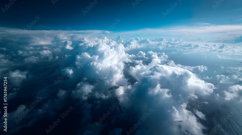 Obraz premium Expansive aerial view of dramatic clouds floating above the deep blue ocean under a clear sky