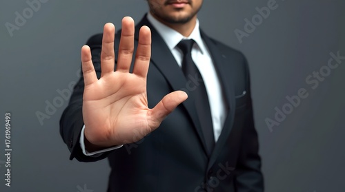A man in a suit extends his hand in a stop gesture