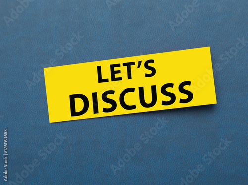 lets discuss. business or education concept. text on a sticker on a blue background