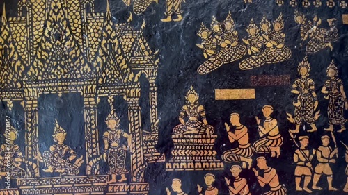 Traditional Thai gold lacquer painting on black background depicting ancient temple scenes and Buddhist stories. Intricate craftsmanship showing Asian cultural heritage and sacred art beauty
