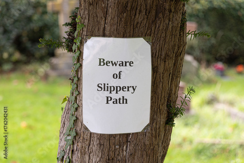 Beware of slippery path sign - countryside background